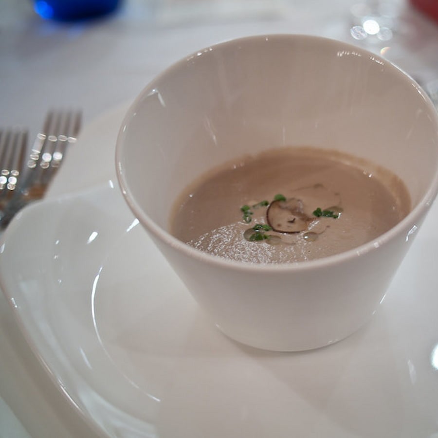 A small delicious portion of cream of mushroom soup in a cup